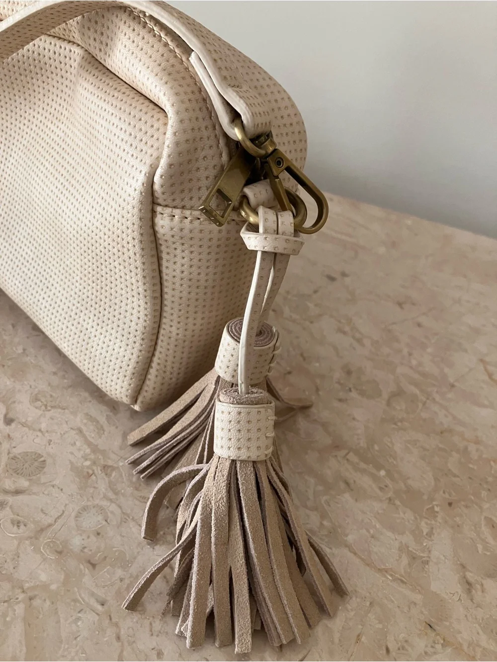 Anthropologie Cream Perforated Crossbody Camera Bag with Tassel